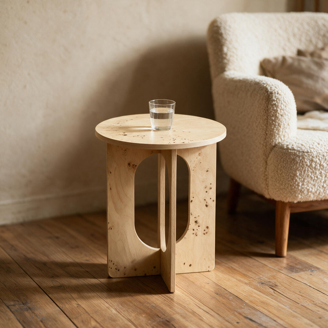 Hoge ronde bijzettafel Ø40 cm in lichte wortelnootlook naast een fauteuil