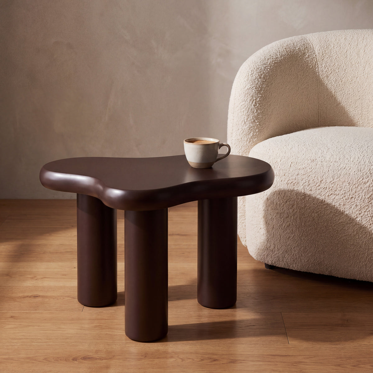 Liora Cloud bijzettafel in chocoladebruin naast een fauteuil, met een kop koffie