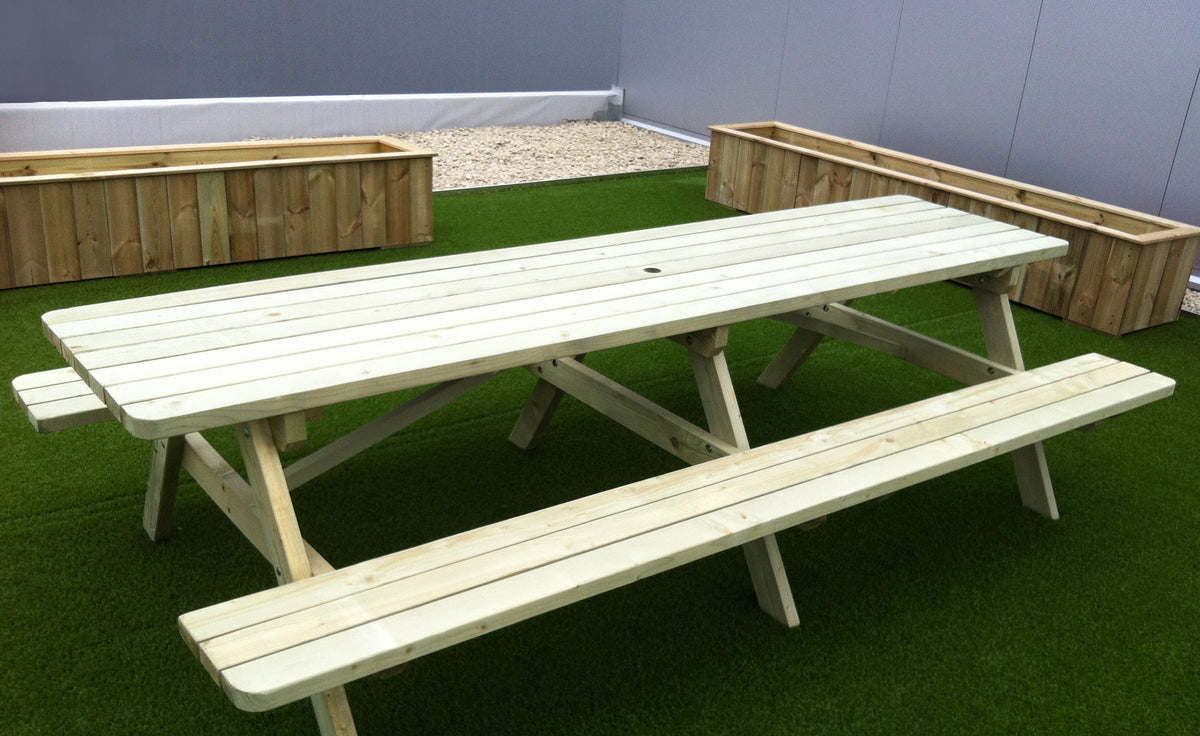 Picknicktafel 300 cm op kunstgras, naast houten plantenbakken