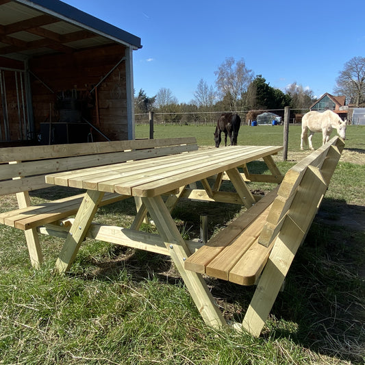 Picknicktafel 300 cm met 2 rugleuningen: de hele tafel op het gras, met paarden op de achtergrond
