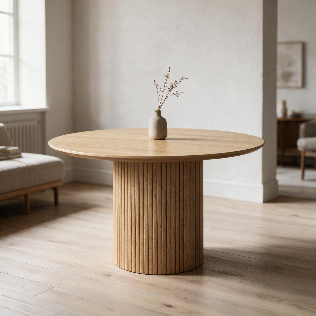 Ronde eettafel met geribbelde trommelvoet in eikenlook, in een lichte eetkamer