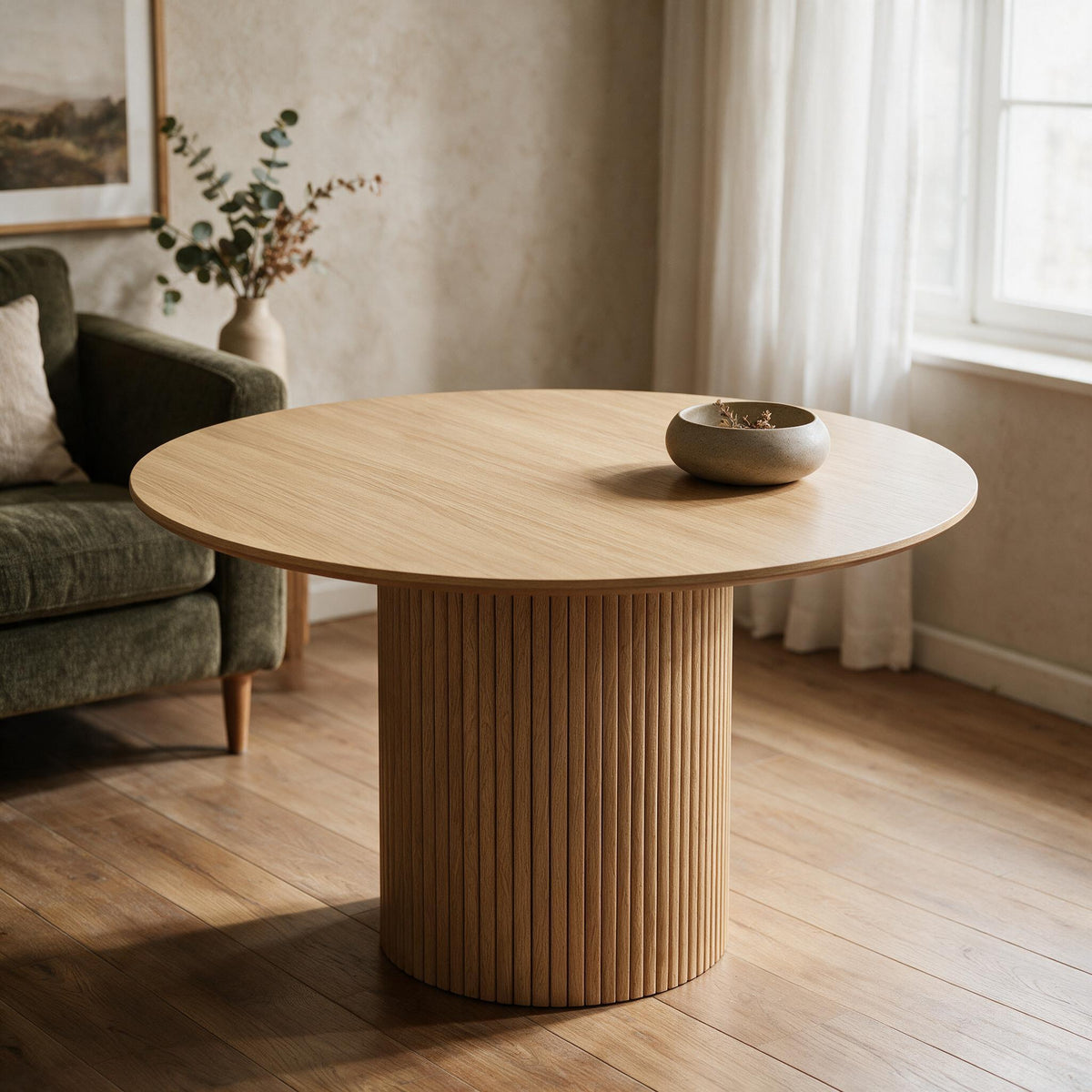 Ronde eettafel met geribbelde trommelvoet in eikenlook, in een warme eetkamer