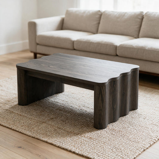 Donkere salontafel met golvend blad voor een beige zetel in een lichte woonkamer