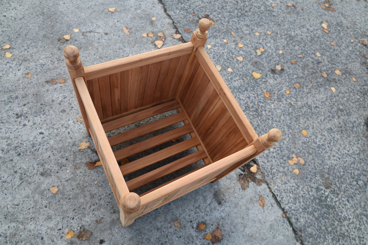 Bovenaanzicht van een teak bloembak: bodem van houten latten