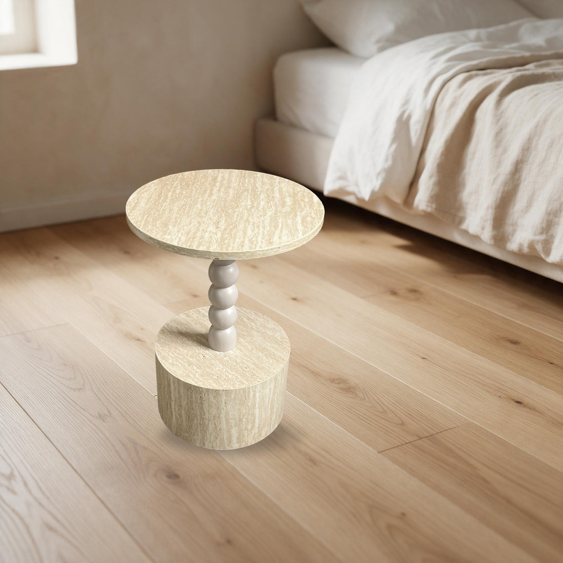 Ronde bijzettafel met bolpoot in travertijnlook als nachtkastje naast een bed