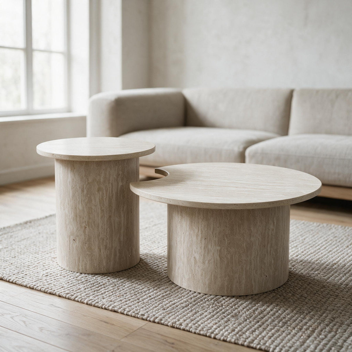 Set van een lage en een hoge ronde tafel in travertijnlook, in een lichte woonkamer