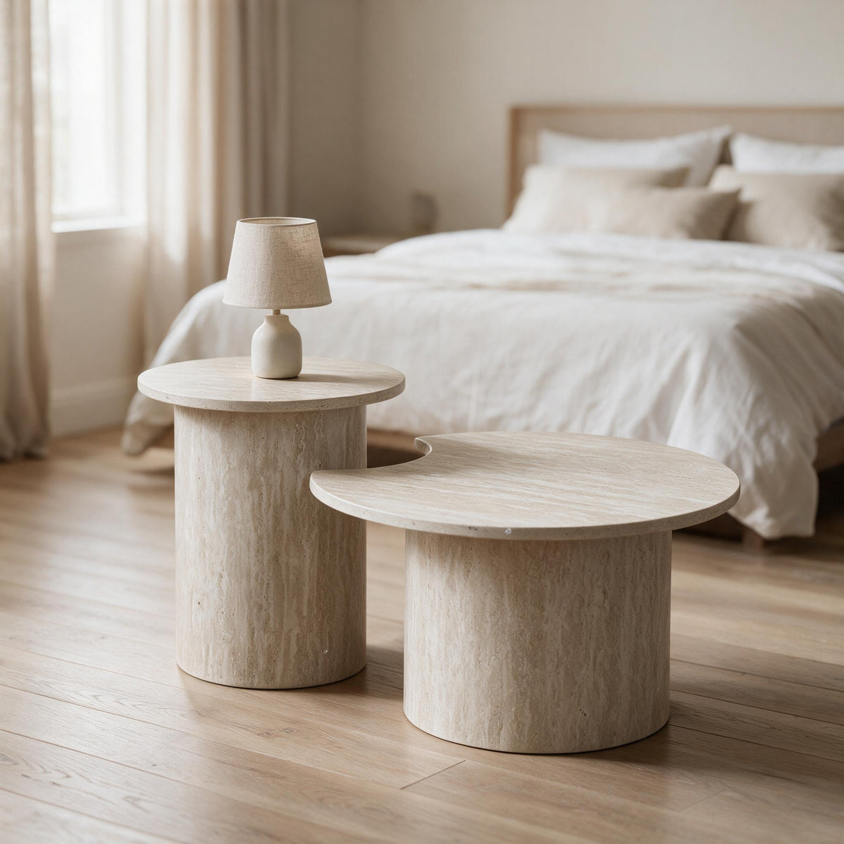Hoge ronde tafel in travertijnlook als nachtkastje naast de lage tafel in een slaapkamer