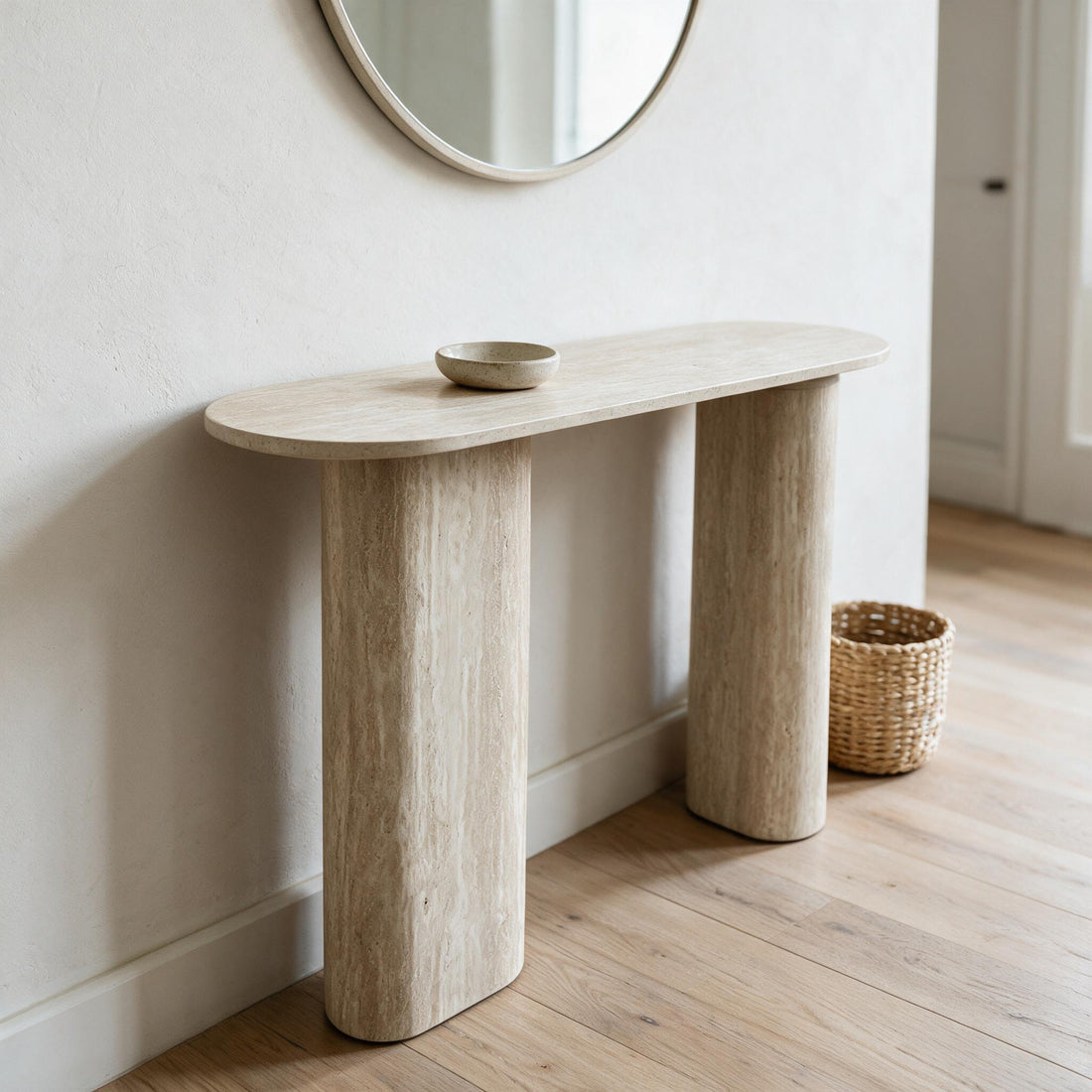 Smalle sidetable in travertijnlook op twee ovale zuilen, in een hal met spiegel
