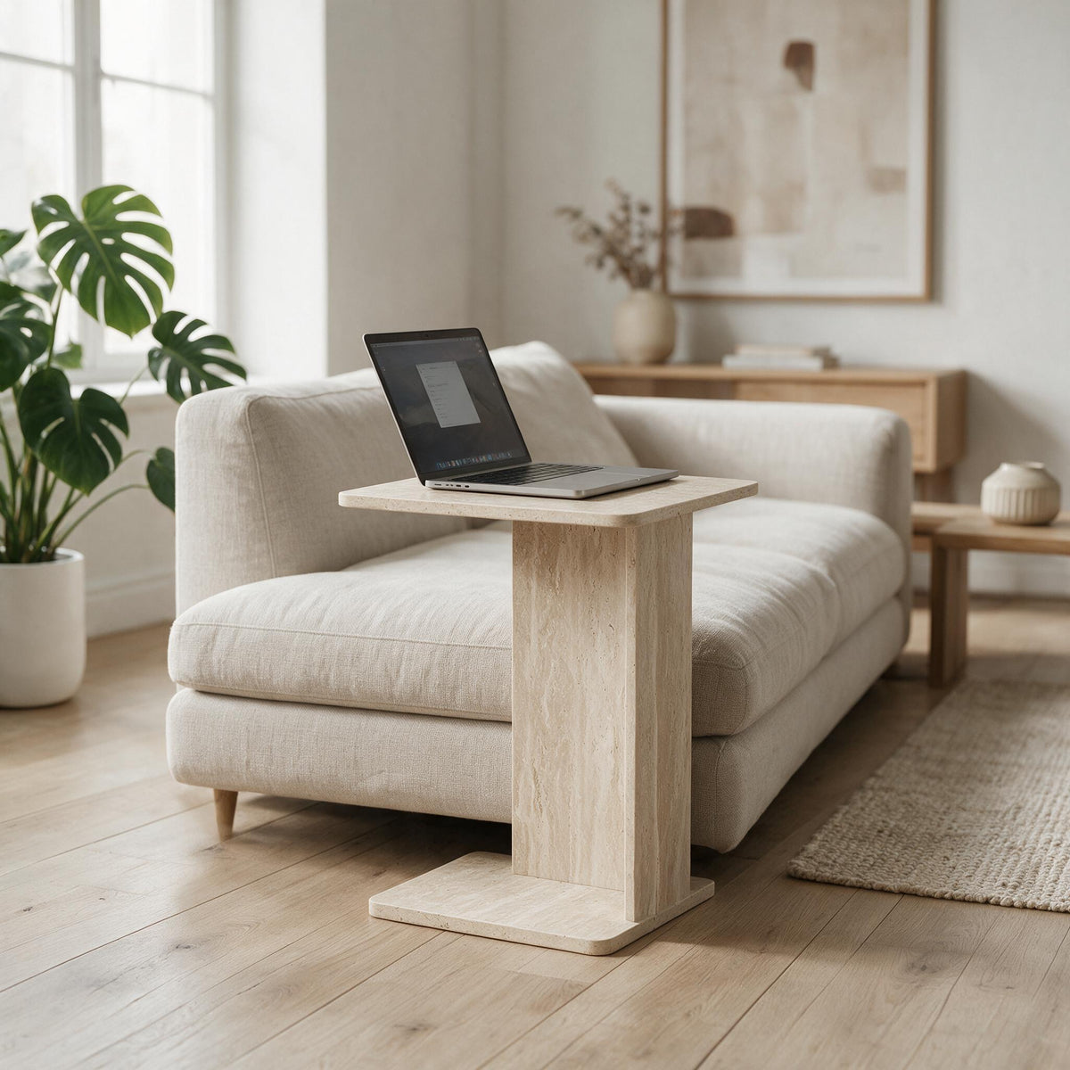 Sofatafel in C-vorm in travertijnlook bij een zetel, met laptop op het blad